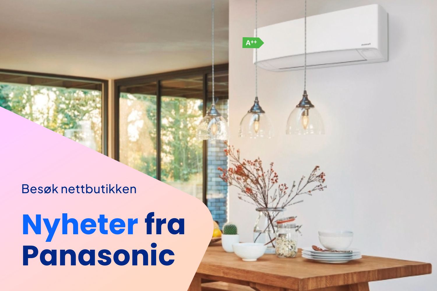 Hvit Panasonic varmepumpe montert på en vegg over et trebord, med hengelamper og A+ energimerking