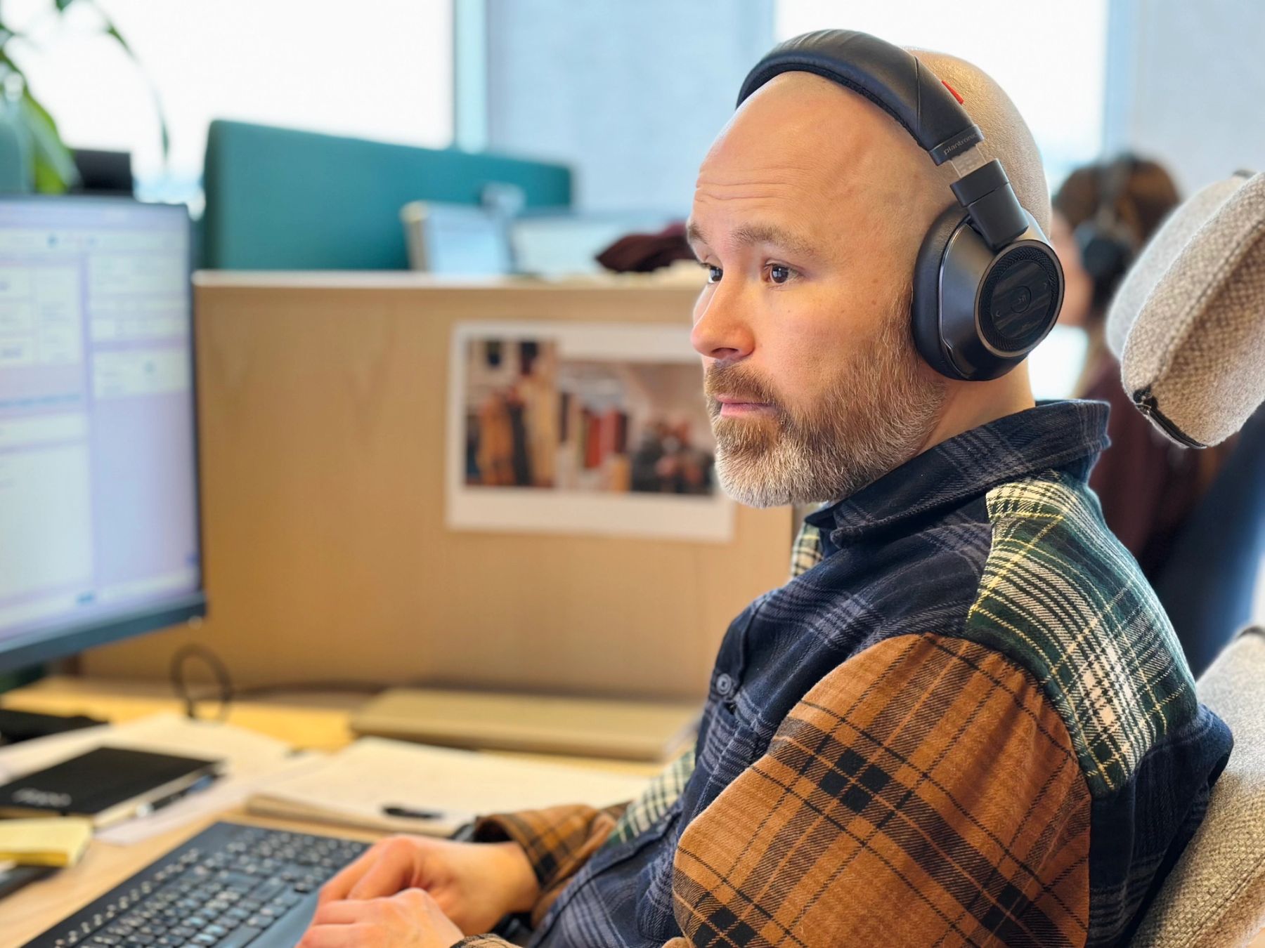 Eskil Gover, fagansvarlig og kunderådgiver i Ishavskraft sitter og tar i mot telefoner fra kunder. Han ser på dataskjermen sin og er konsentrert, og har hodetelefoner på.