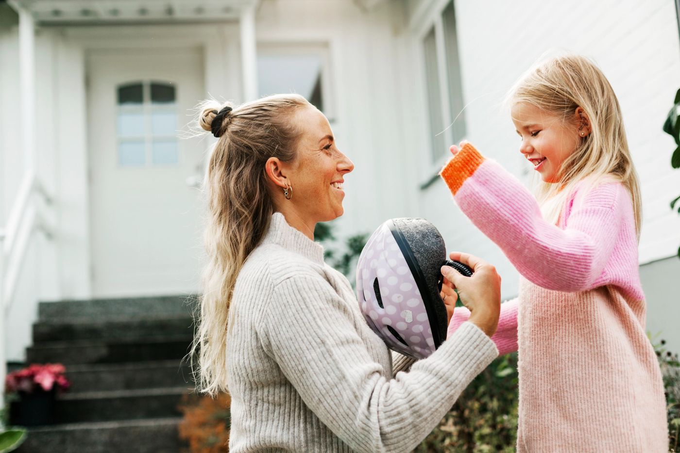 En ung familie leker sammen. Moren ser ned på barnet sitt på 2 år mens hun kiler han, og faren passer på og holder rundt dem. Et flott øyeblikk.