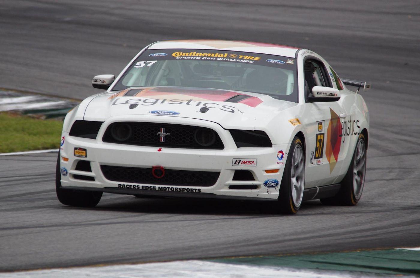 A white race car on a track Description automatically generated with medium confidence