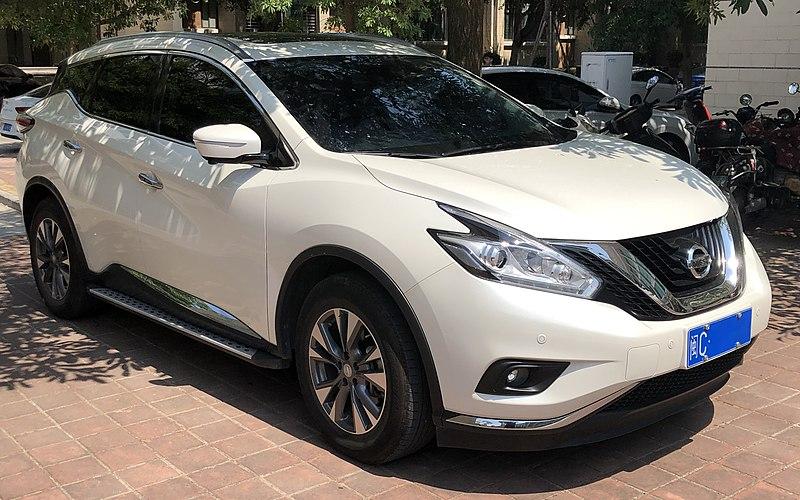 A white car parked on a brick road Description automatically generated with medium confidence