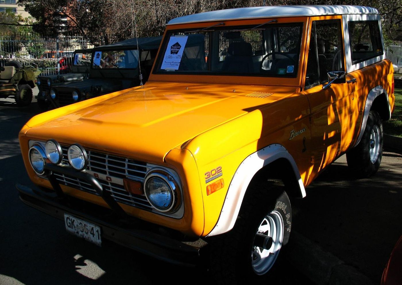 An orange truck parked on the side of the road Description automatically generated with medium confidence