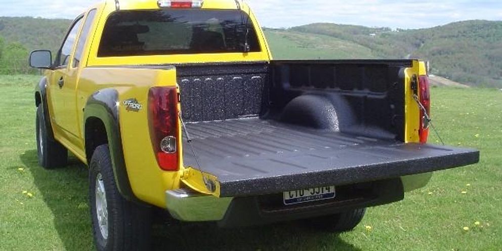 yellow pickup truck on hill, open truck bed