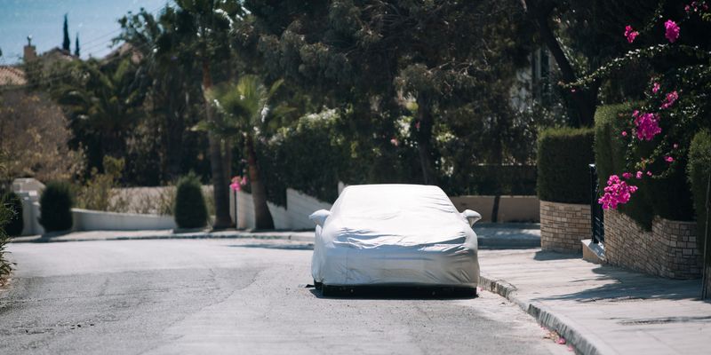 car-under-protective-cover-near-house