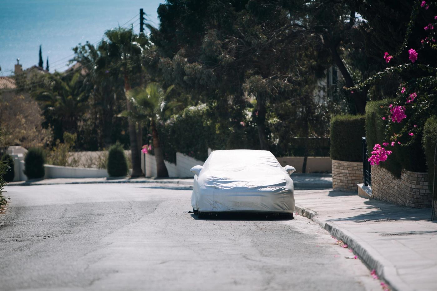 car-under-protective-cover-near-house