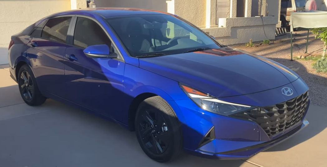 A blue car parked on a driveway Description automatically generated with low confidence