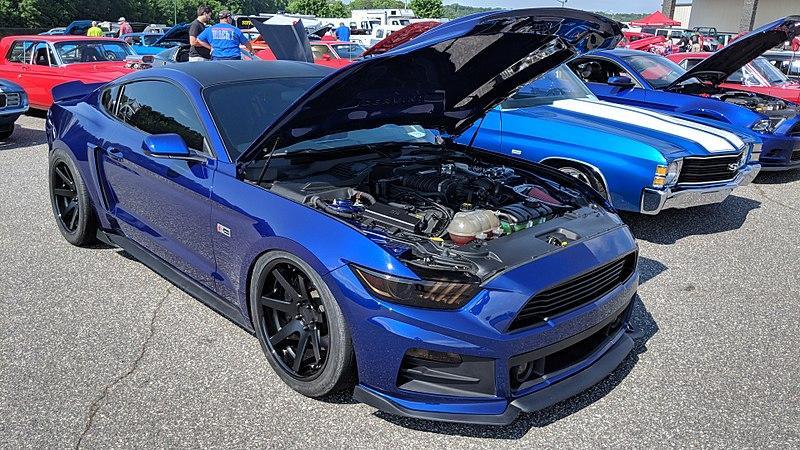 A blue car with its hood open Description automatically generated with low confidence