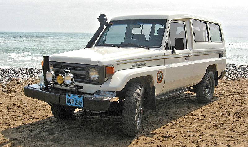 white toyota land cruiser on beach sand