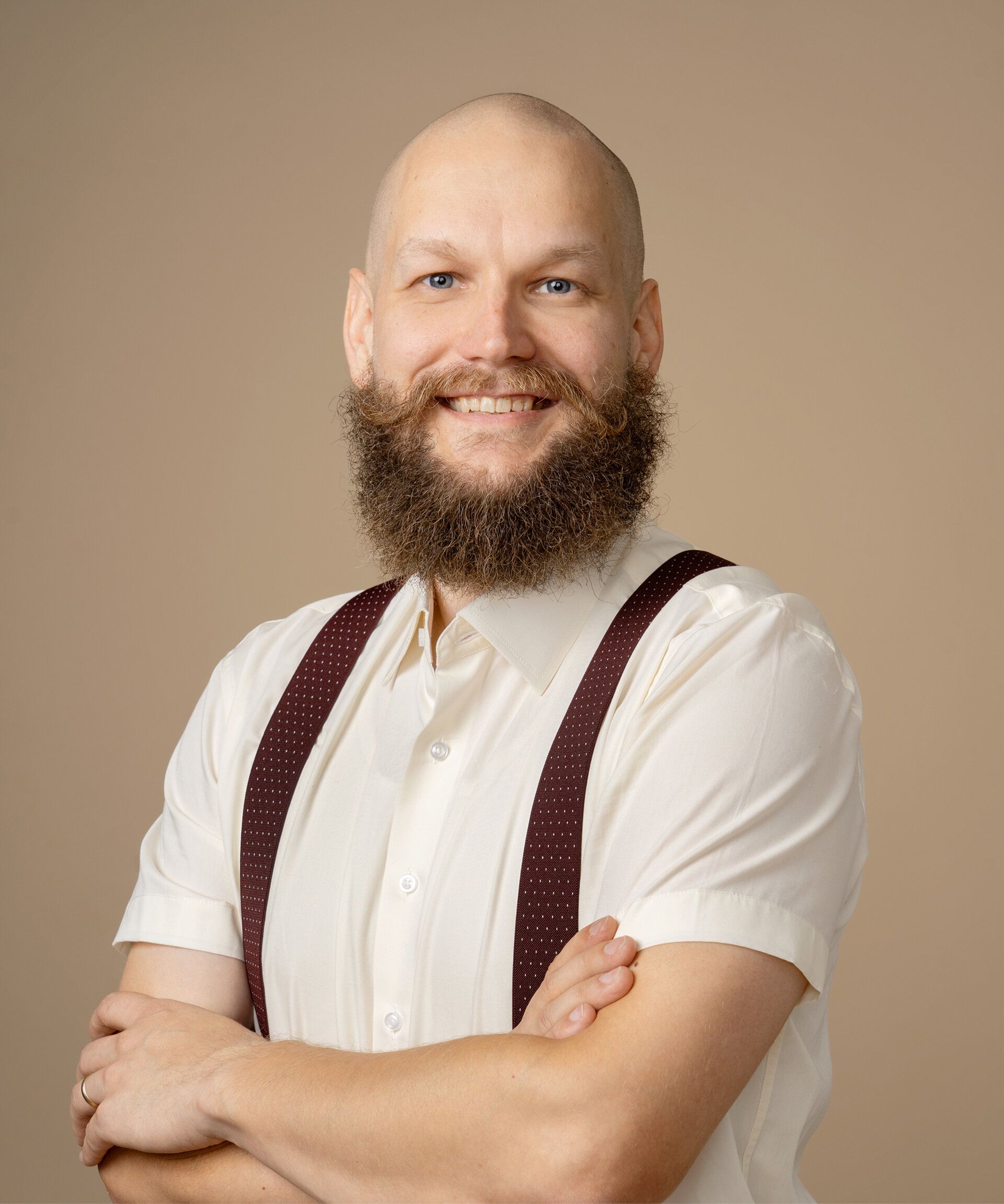 A bald smiling man with a beard in a black t-shirt