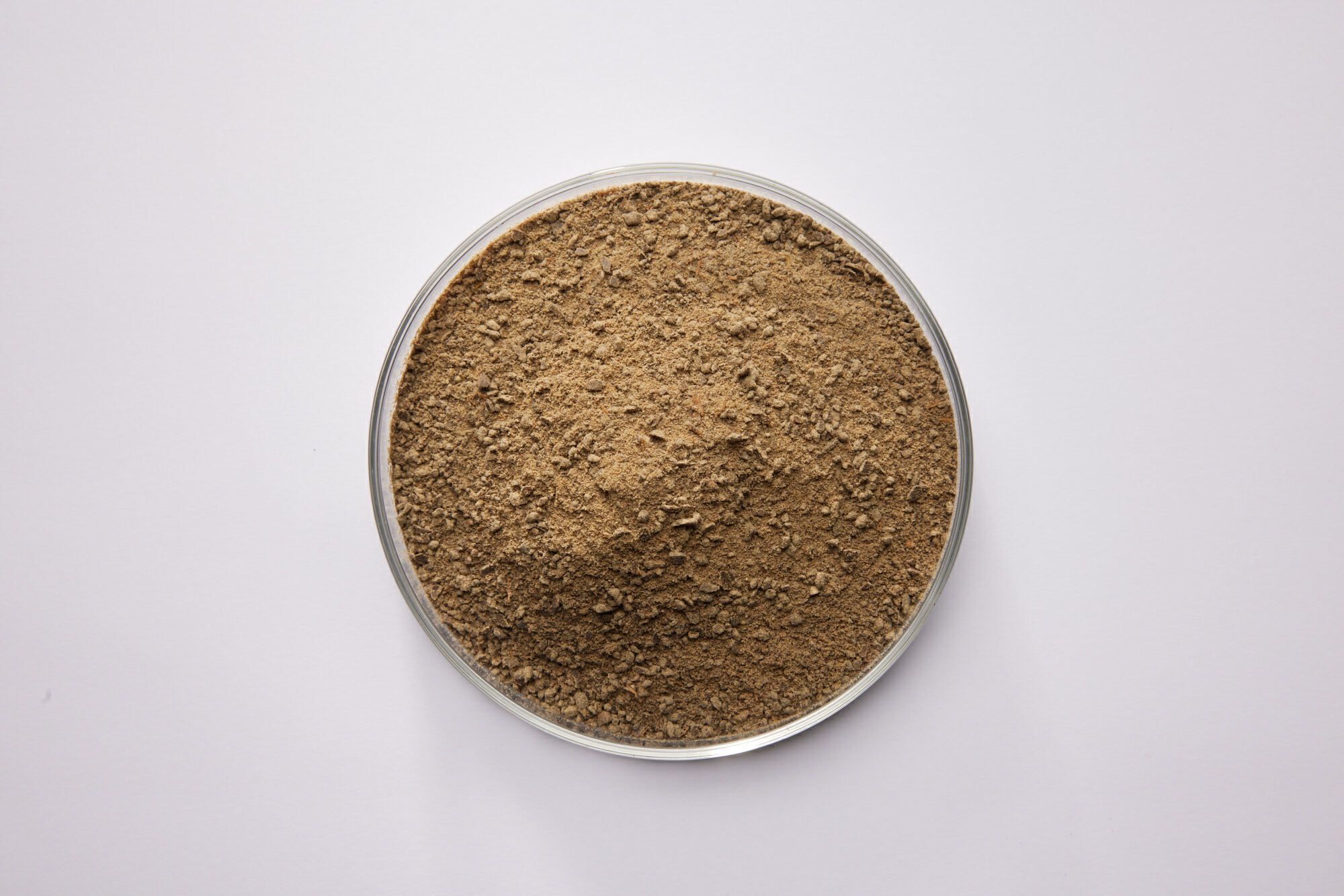 Earthy powder in a petri dish on a white background
