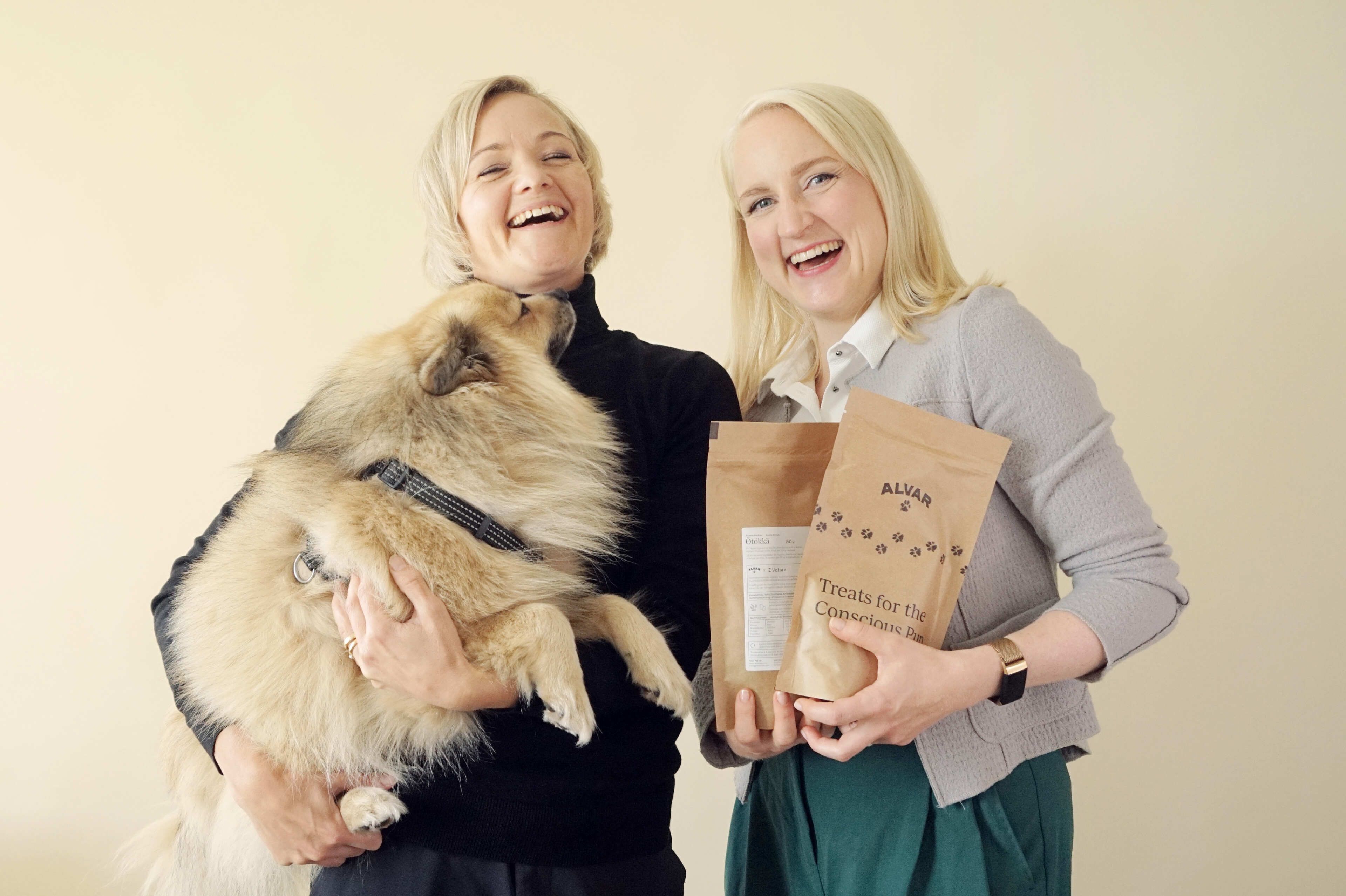 Laughing Alvar and Volare representatives holding Alvar treats and a fluffy dog 