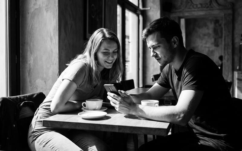 Two young people meeting for the first time at a Prague cafe