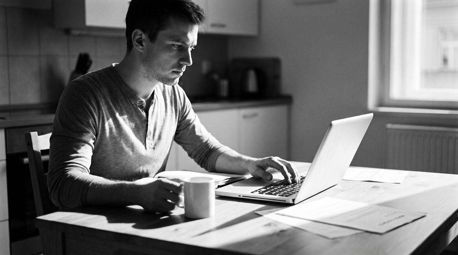 Young professional working out a rent budget at a kitchen table