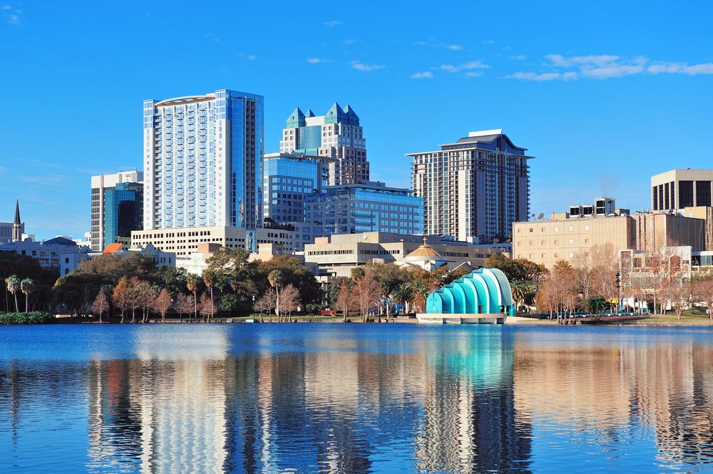 Urban skyline reflecting in a lake on a bright, sunny day