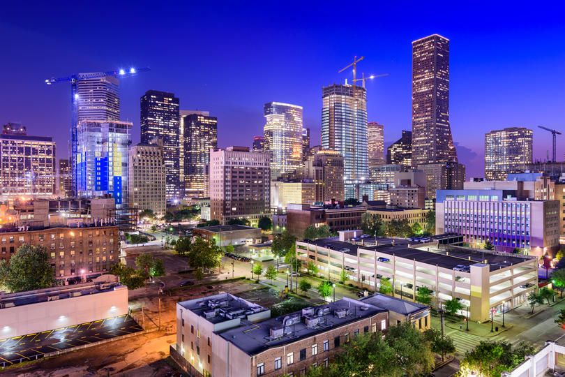 Urban skyline at twilight with construction cranes and illuminated buildings