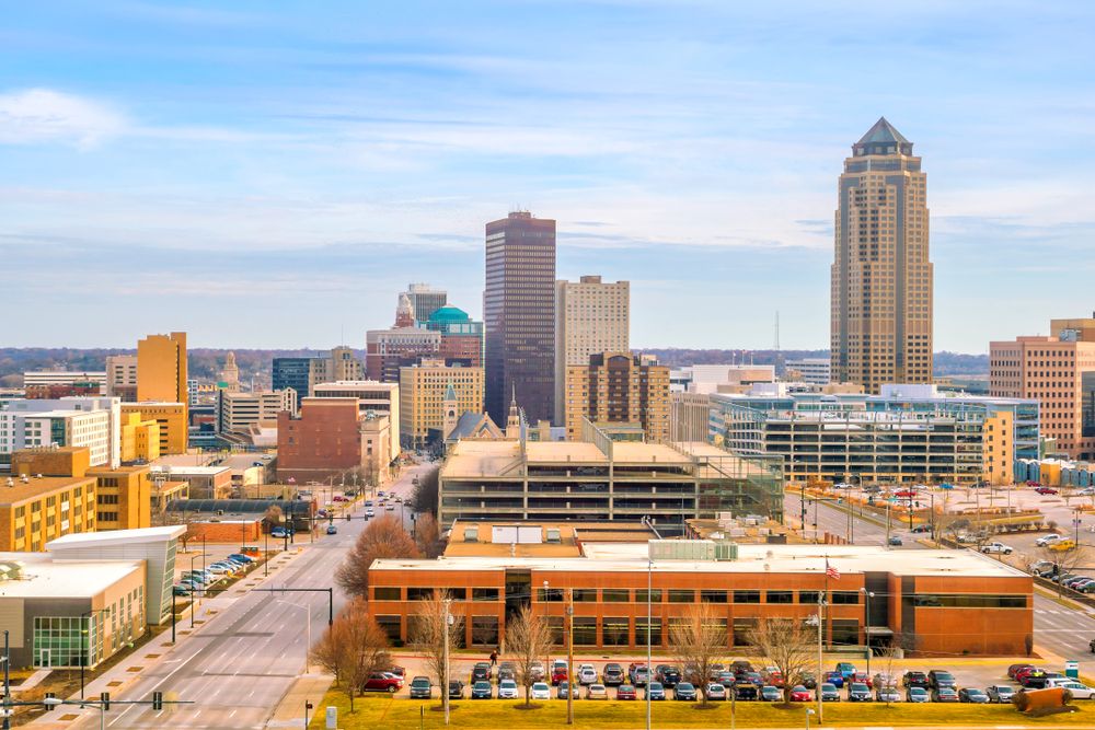 Urban skyline with a variety of office towers, parking structures, and roads under a bright blue sky.