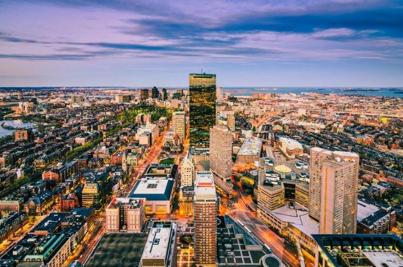 Villes ayant le plus de cas d’asthme – Image de la ligne d’horizon de Boston, montrant de grands immeubles, la circulation sur les autoroutes et un ciel coloré en arrière‑plan.