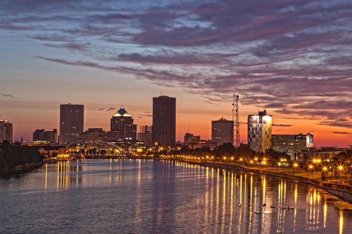 Colorful city skyline with unique architecture and lit-up buildings at dusk.