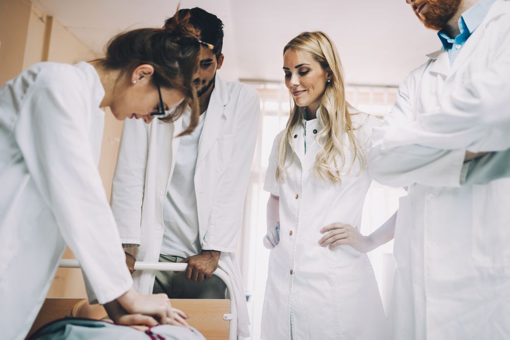 Group of medical students or healthcare professionals practicing CPR on a mannequin