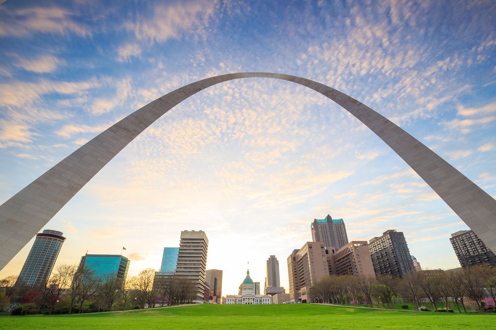 St. Louis, Missouri skyline framed by the iconic Gateway Arch with sunrise in the background.