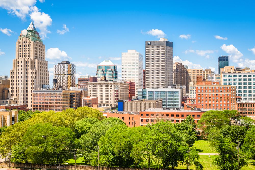 Cities With the Most Residents Who Smoke -Infographics of Downtown Cleveland, Ohio with green parks in the foreground, among the U.S. cities with elevated smoking prevalence.