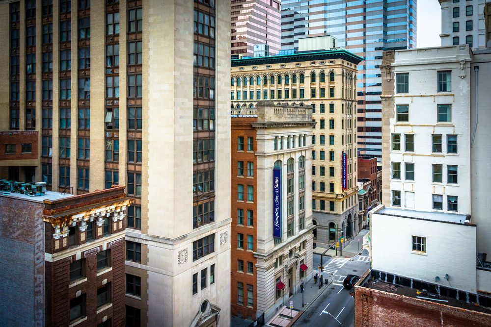 Cluster of older high-rise buildings with narrow city streets in between and mix of architectural styles.