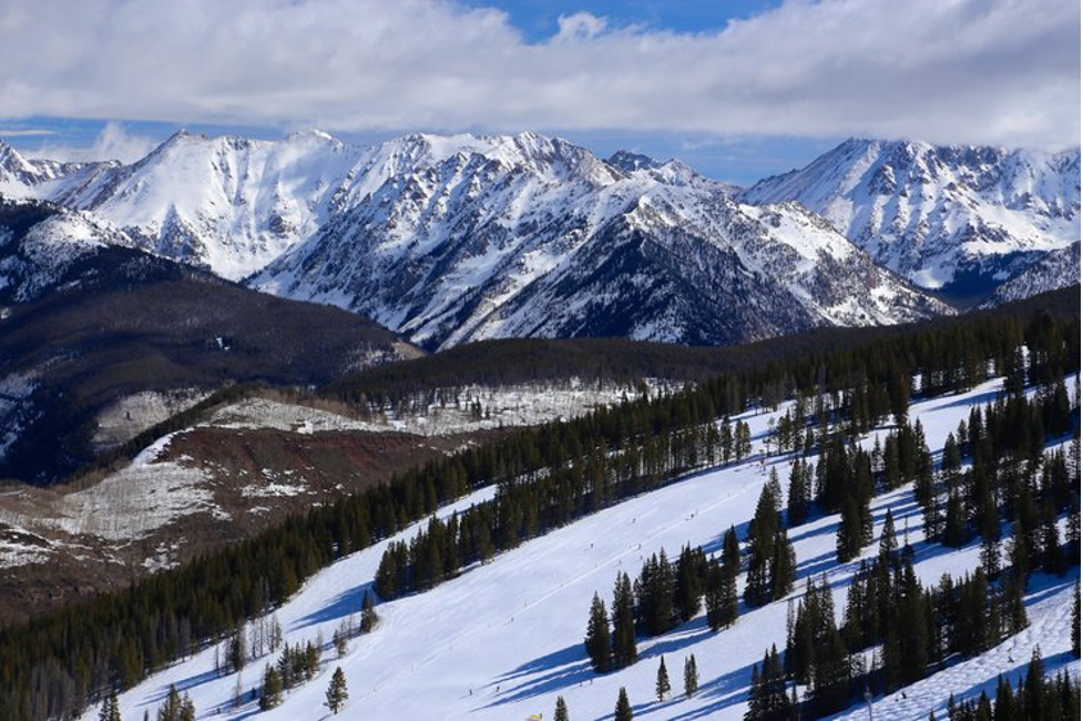 Snow-covered Rocky Mountains with pine trees and ski slopes in Colorado