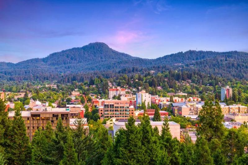View of Eugene, Oregon framed by forested hills, illustrating the state's growing housing instability risks.