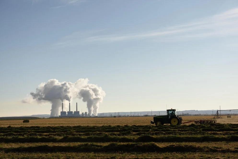 Image of an industrial facility emmiting steam form its vents and chimneys which signifies that it is back in business.