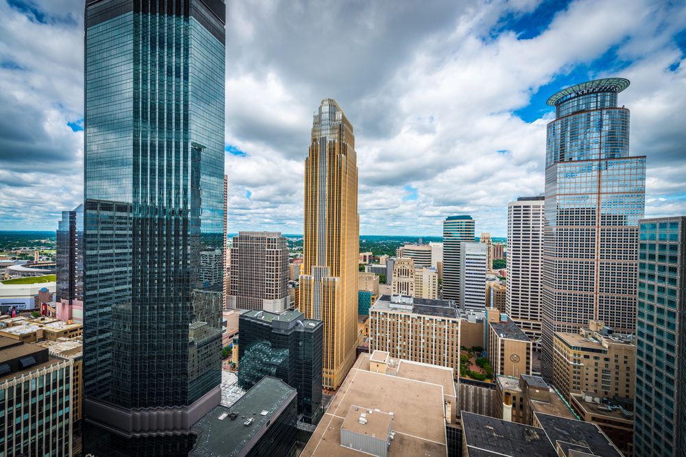 Downtown Minneapolis, Minnesota skyline with tall modern buildings under a partly cloudy sky.