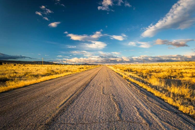 The Hottest City in Every State - Infographics of a Sunlit desert road near Roswell, New Mexico’s hottest city with over 100 days above 90°F each year.