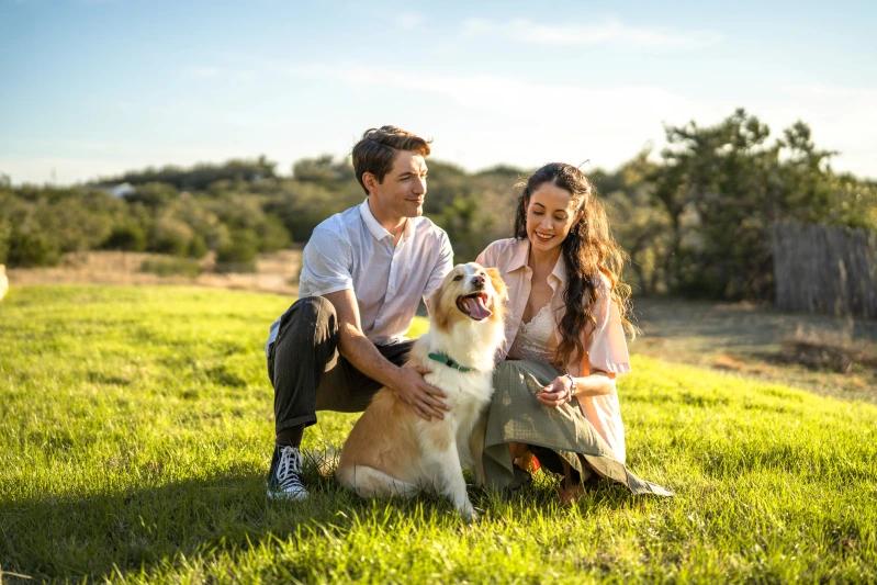 Vue de propriétaires d’animaux caressant affectueusement leur chien dans l’arrière‑cour.