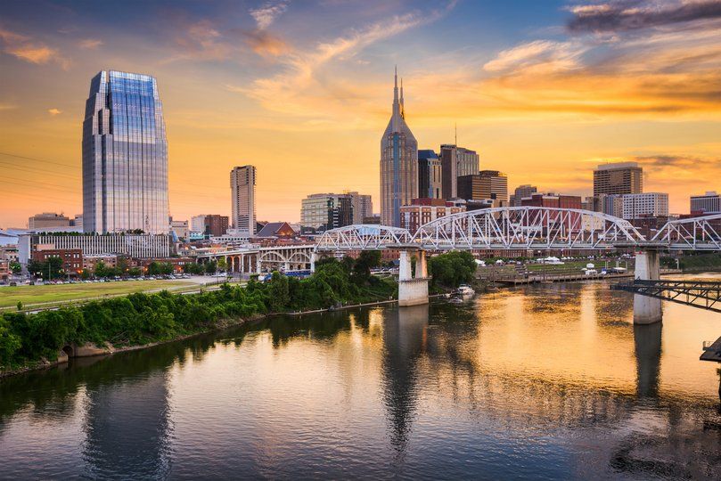 Riverfront skyline at sunset with a bridge crossing over water