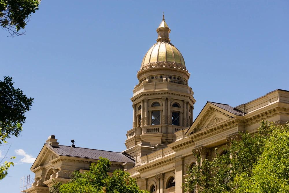 States Where Residents Are Spending the Most on Groceries - Infographics of Close-up of the gold-domed Wyoming State Capitol in Cheyenne, highlighting grocery costs in Wyoming