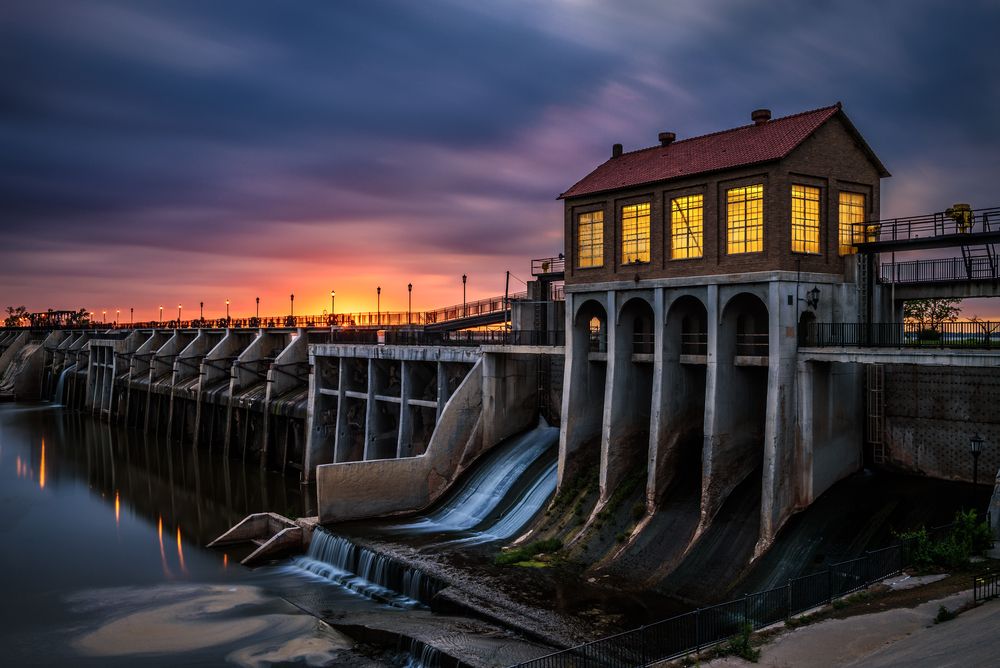 States With the Most Korean War Vets - Infographics of a  Power plant with dam and sunset, representing infrastructure near communities with Korean War veterans.