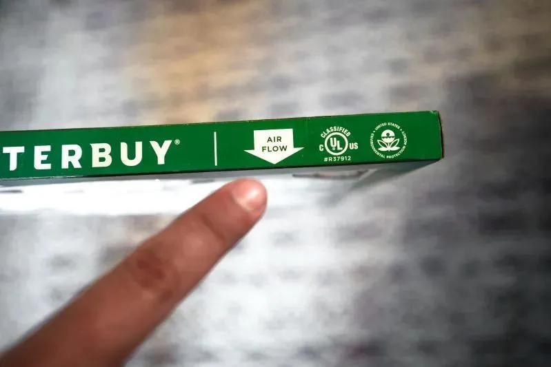 Best Air Purifier Replacement Filters - image of a person pointing at a green Filterbuy air filter label with airflow direction and certification icons.
