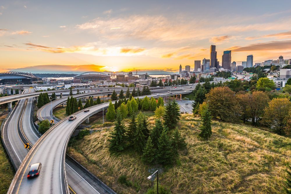 Vue aérienne de l’horizon de Seattle avec échangeurs autoroutiers au lever du soleil.