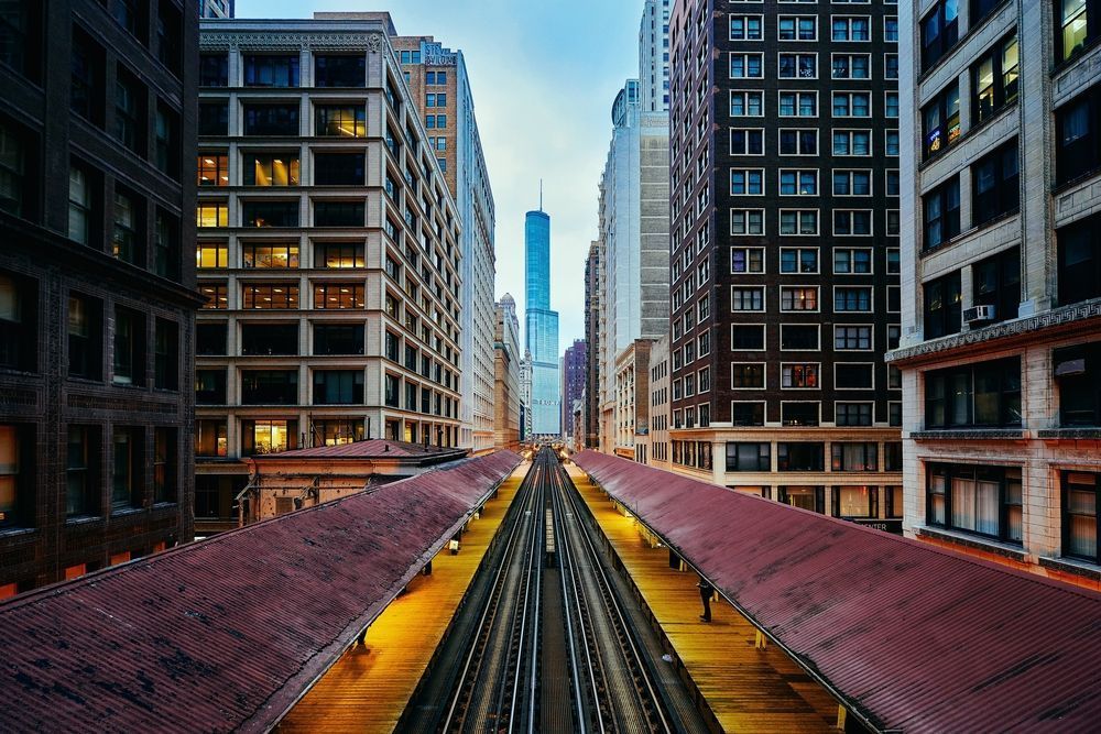 Station du L de Chicago entre de grands immeubles avec la Willis Tower en arrière‑plan.