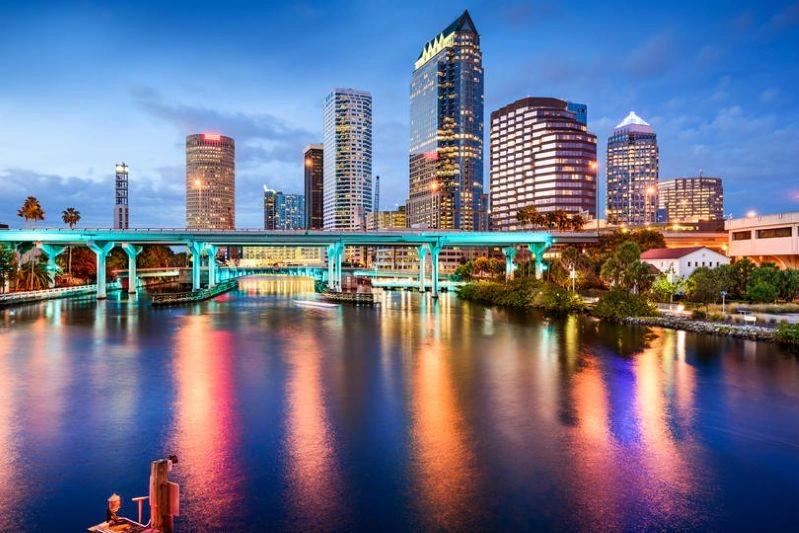 Villes ayant connu les plus fortes baisses de la pollution de l’air : silhouette de Tampa avec un pont traversant l’eau, éclairé la nuit, reflétant les lumières de la ville.