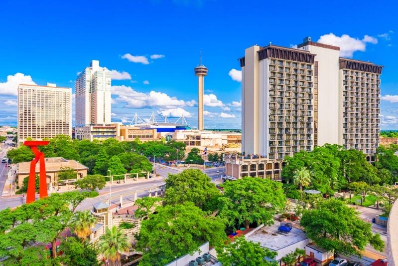 Cities With the Most Multigenerational Households - Image of San Antonio cityscape with the Tower Life building and the Tower of the Americas in the background, featuring green spaces and urban architecture.