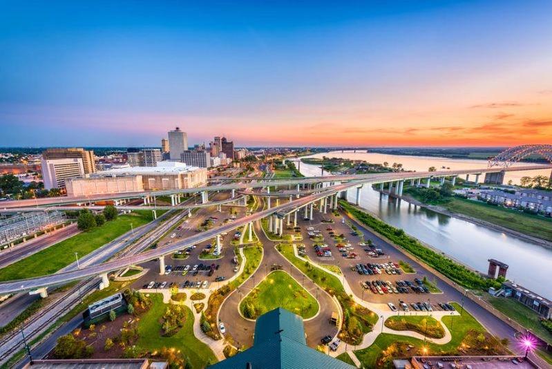 Villes ayant connu les plus fortes baisses de la pollution de l’air : silhouette de Memphis montrant autoroutes et front de rivière, avec des ponts et le centre‑ville au coucher du soleil.