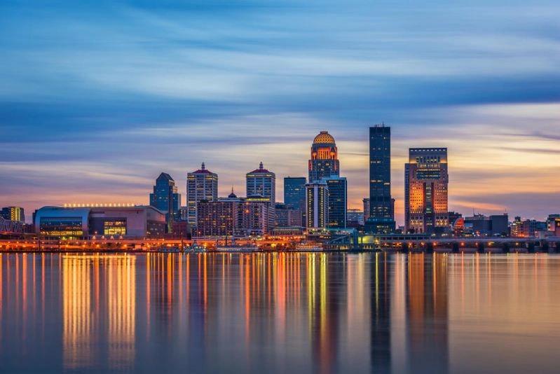 Villes ayant connu les plus fortes baisses de la pollution de l’air : silhouette de Louisville de nuit avec les lumières de la ville se reflétant sur la rivière.