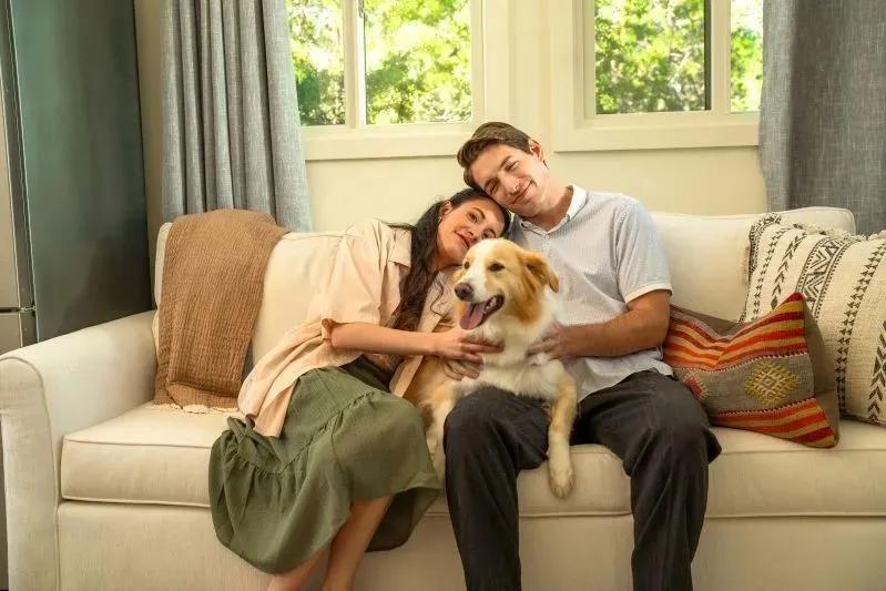 The Ultimate Guide to Air Conditioning Vent Filters for Home - image of a couple on a couch with their happy dog in a cozy, sunlit living room.