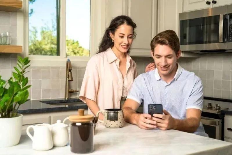 Comment nettoyer votre hotte de cuisine, la ventilation de la cuisinière et le filtre comme un pro : image d’un couple apprenant à nettoyer ensemble le filtre de ventilation d’une hotte de cuisine.