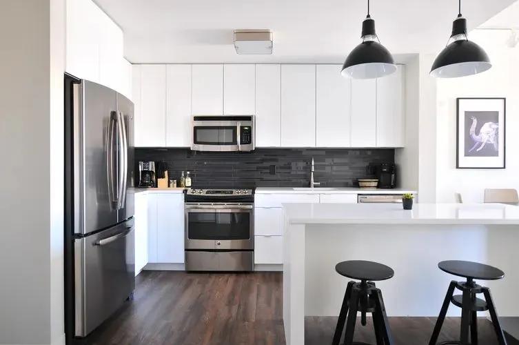 Image of a modern kitchen with stainless steel appliances and minimalist bar seating.