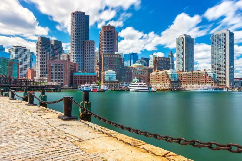 View of Boston waterfront skyline highlighting the city’s severe Millennial renter wage gap amid high housing costs.