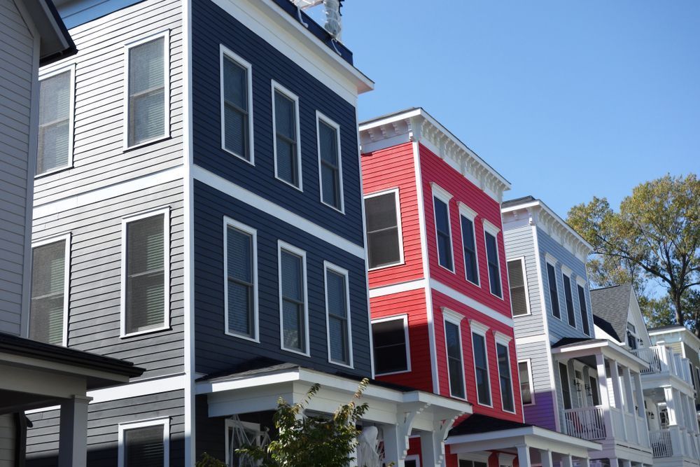 Rangée de maisons en rangée modernes et colorées sous un ciel bleu dégagé.