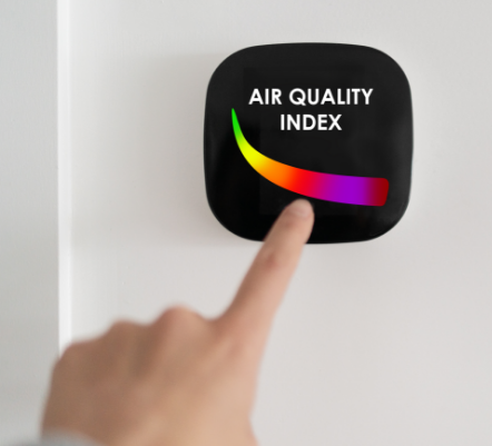 A view of a person pointing at an air quality index monitor.