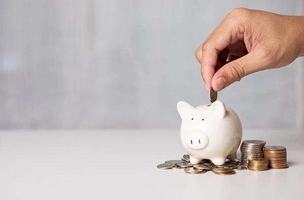 View of a hand saving money in a piggy bank—represents affordable air filter subscriptions.