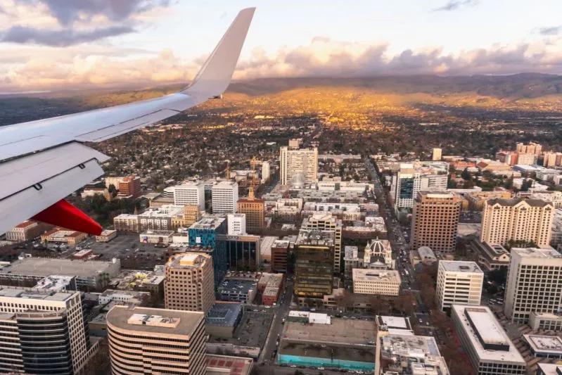 Vue de la silhouette de San Jose depuis un avion mettant en lumière l’importante disparité salariale des milléniaux locataires dans la Silicon Valley.